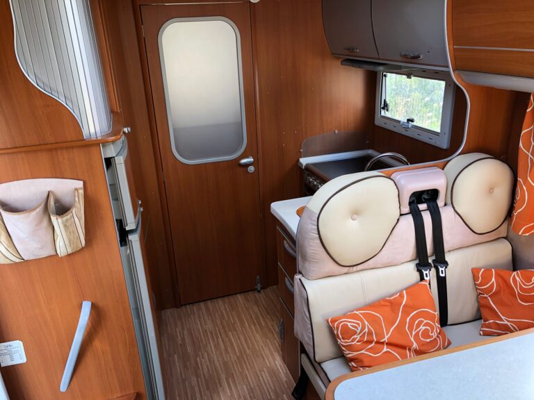 Intérieur moderne de caravane avec sièges oranges.