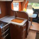 Intérieur lumineux de camping-car avec cuisine équipée.