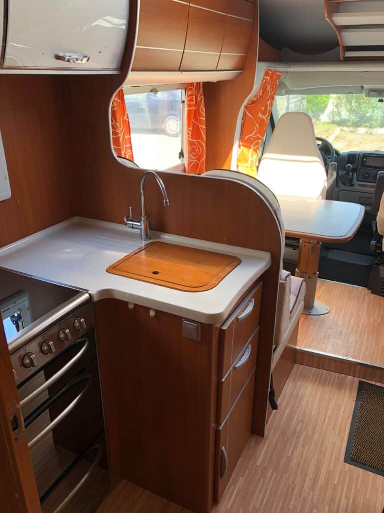 Intérieur lumineux de camping-car avec cuisine équipée.