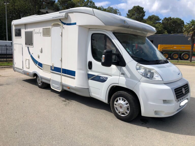 Camping-car blanc stationné en extérieur.