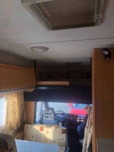 Intérieur lumineux de camping-car avec sièges et fenêtre.