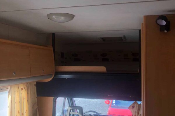 Intérieur lumineux de camping-car avec sièges et fenêtre.