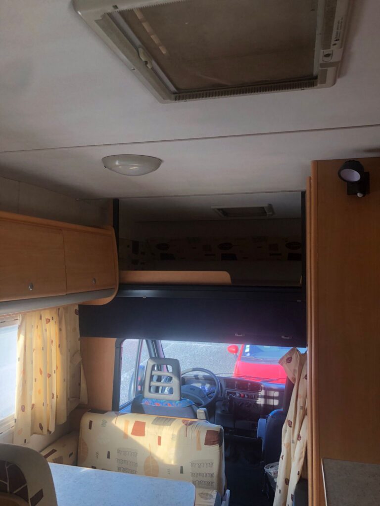 Intérieur lumineux de camping-car avec sièges et fenêtre.