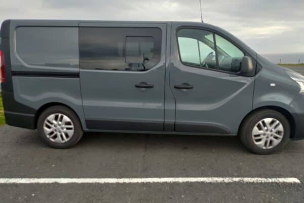 Fourgonnette grise parquée sur un parking.