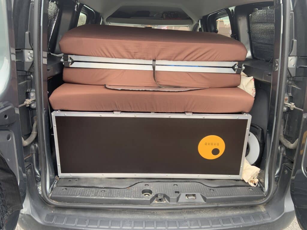 Matelas pliés dans le coffre d'un fourgon.