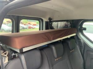 Intérieur de van avec lit suspendu marron.