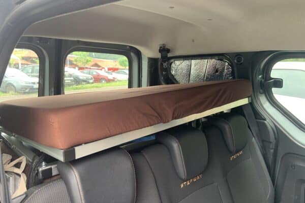 Intérieur de van avec lit suspendu marron.