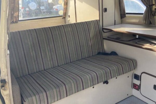 Intérieur de camping-car avec banquette rayée.