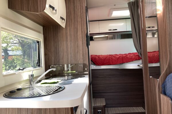 Moderne Inneneinrichtung von Wohnmobil mit Küche und Bett