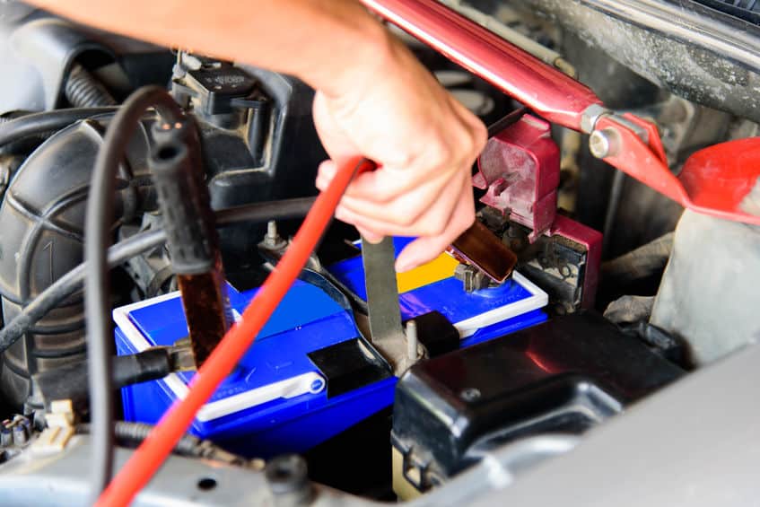 Mains changeant une batterie de voiture