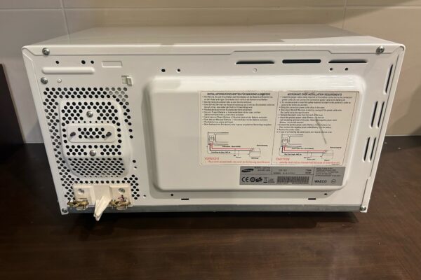Retro di un microonde bianco con etichette e connettori