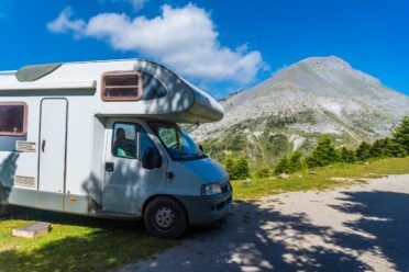 Camping-car devant montagne pittoresque sous ciel bleu