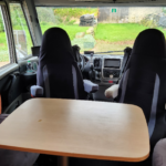 Intérieur de camping-car avec sièges et table en bois
