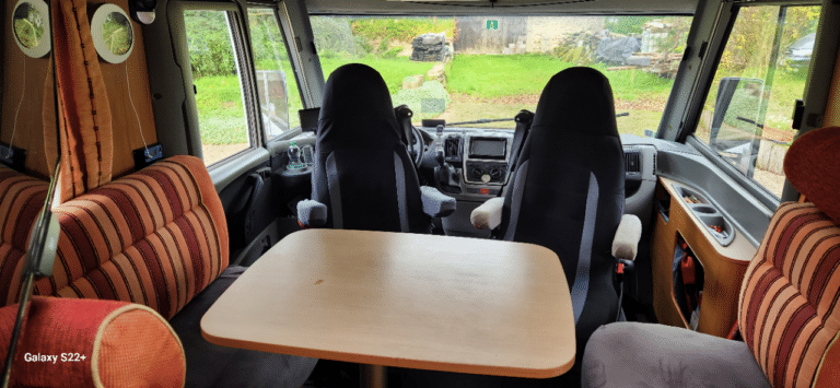 Intérieur de camping-car avec sièges et table en bois
