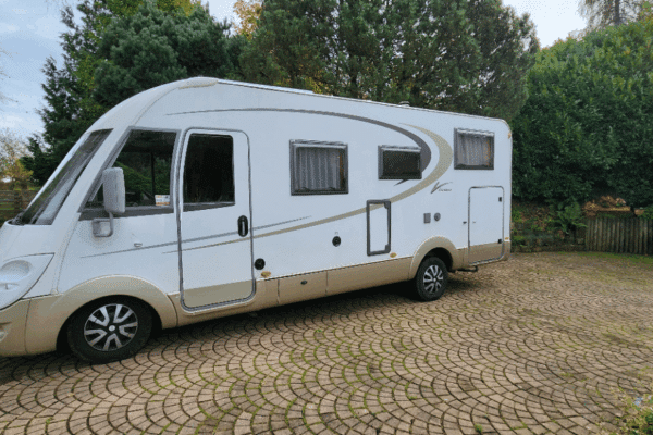 Camping-car moderne garé devant une maison