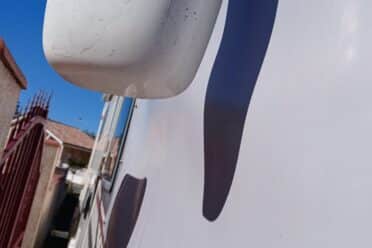 Vue partielle d'un camion blanc, logo visible, ciel bleu