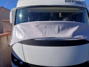 Camion blanc avec bâche protégeant le pare-brise
