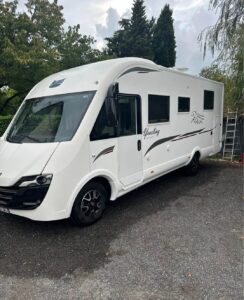 Camping-car blanc moderne garé en extérieur