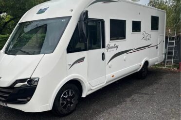 Camping-car blanc moderne garé en extérieur