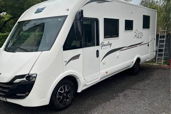 Camping-car blanc moderne garé en extérieur