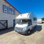 Camping-car blanc devant Atelier Van&Co sous soleil