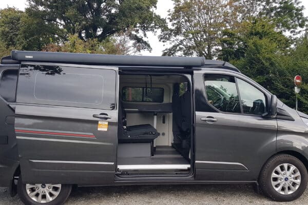 Fourgonnette grise avec porte ouverte et équipement intérieur