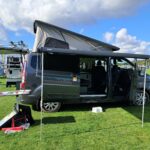 Camping-car ouvert sur terrain verdoyant