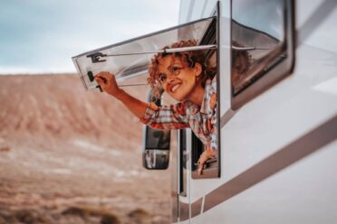 Femme souriante regardant depuis un camping-car