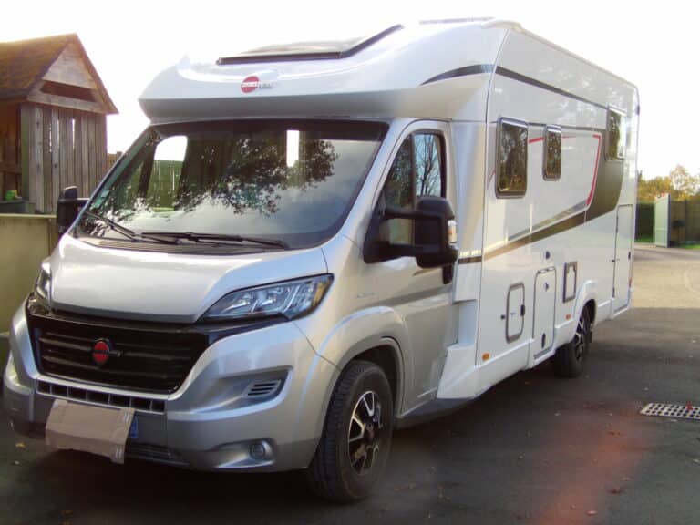 Camping-car moderne blanc stationné en extérieur