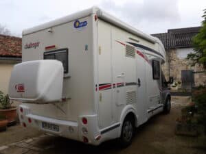 Camping-car blanc Challenger garé dans une cour