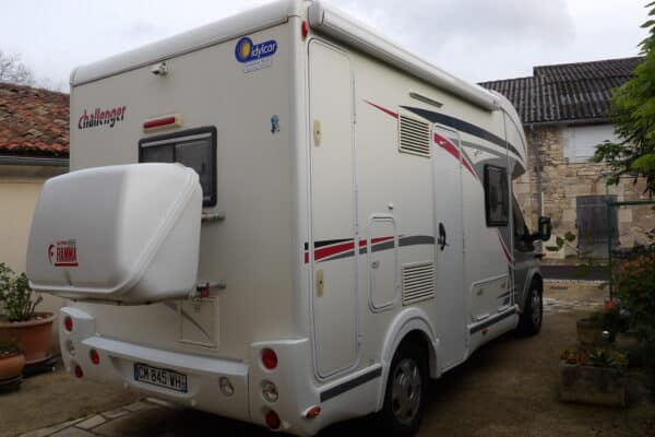 Camping-car blanc Challenger garé dans une cour