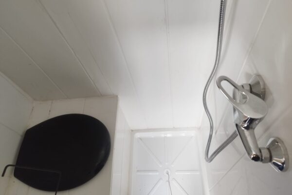 Dusche mit verchromtem Duschkopf und schwarzem Hängesitz