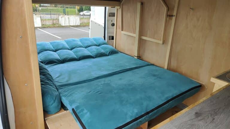 Intérieur de camionnette aménagée avec lit turquoise