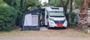 Camping-car et auvent dans un cadre verdoyant