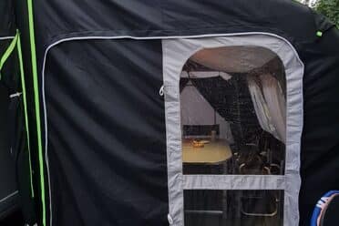 Tente de camping noire avec porte ouverte