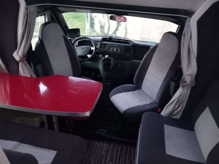 Intérieur de camping-car avec sièges et table rouge