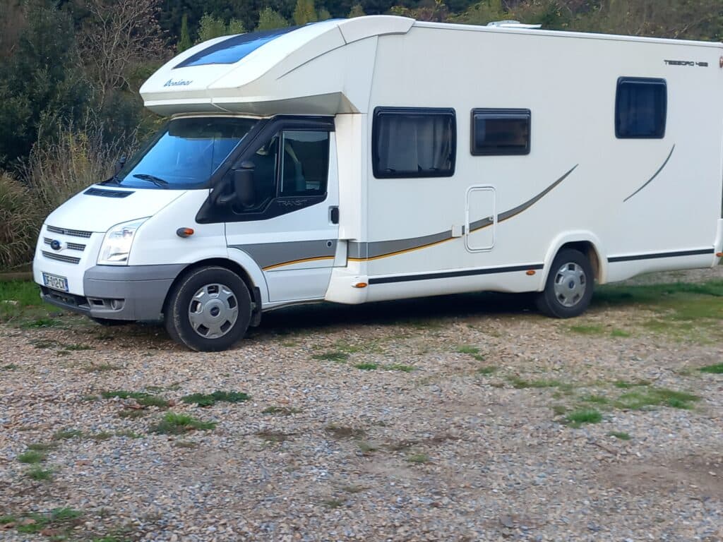 Camping-car blanc stationné en nature