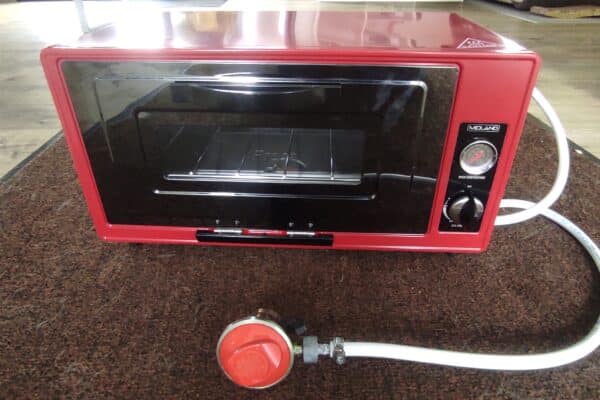 Forno elettrico portatile rosso su un tappeto
