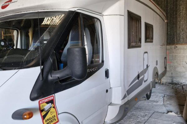 Wohnmobil weiß geparkt in einem Hangar