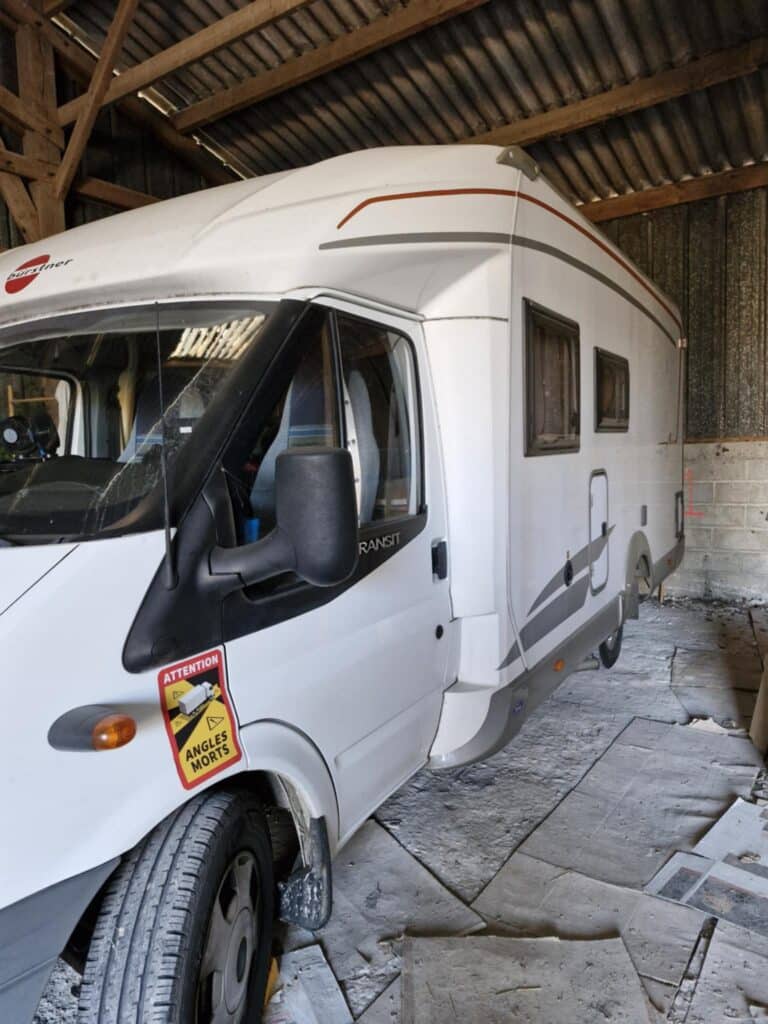 Camping-car blanc stationné dans un hangar
