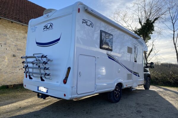 Wohnmobil modern geparkt vor altem Gebäude