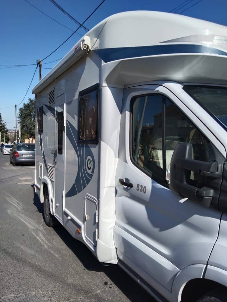 Camping-car blanc garé sous le soleil