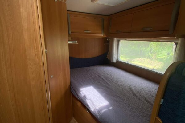 Intérieur cosy de caravane avec lit et fenêtre