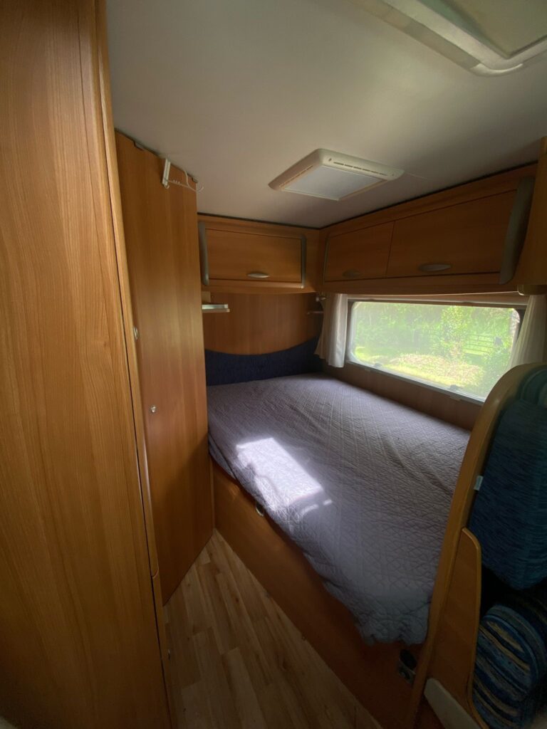 Intérieur cosy de caravane avec lit et fenêtre