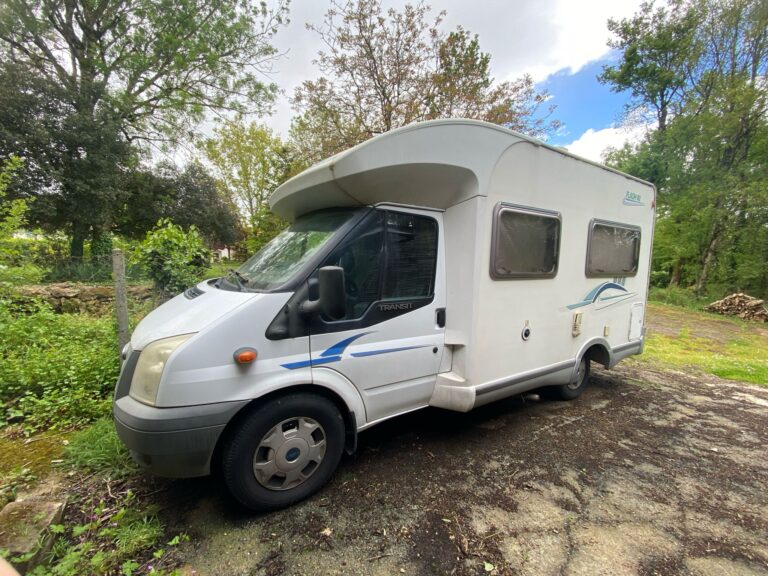 Camping-car blanc stationné en milieu naturel