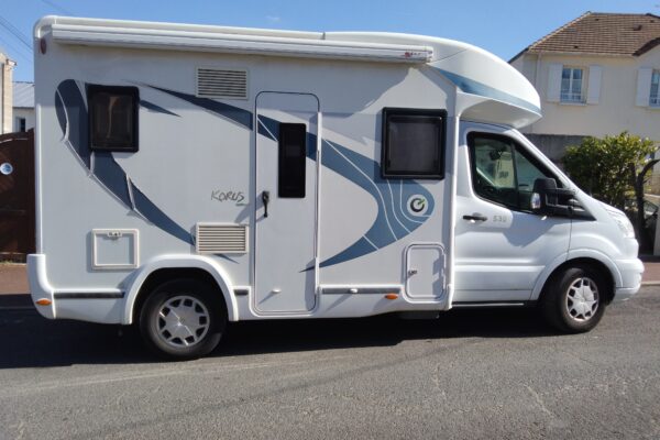 Camping-car blanc stationné dans une rue ensoleillée