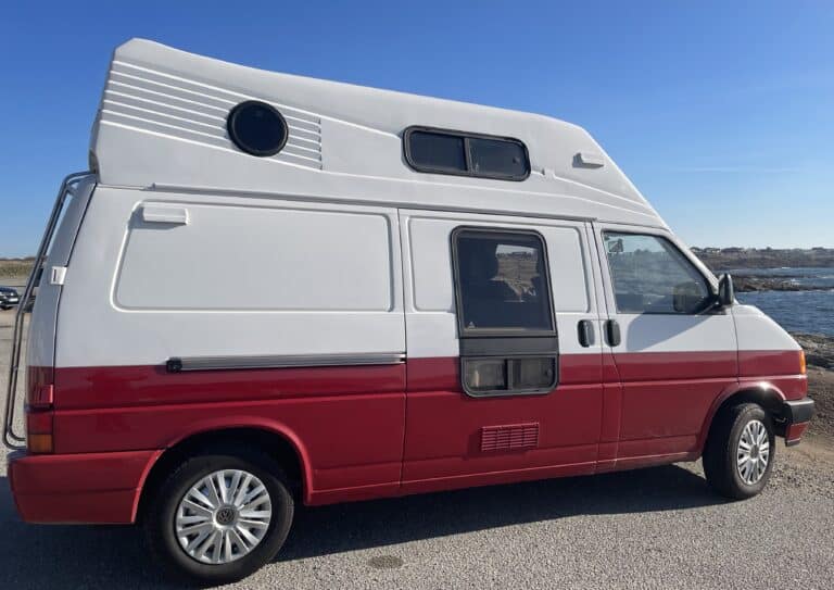 Camping-car rouge et blanc près de la mer