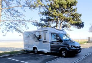 Camping-car garé près de la plage sous des pins