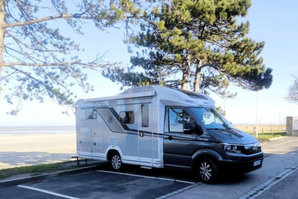 Wohnmobil geparkt in der Nähe des Strandes unter Pinien