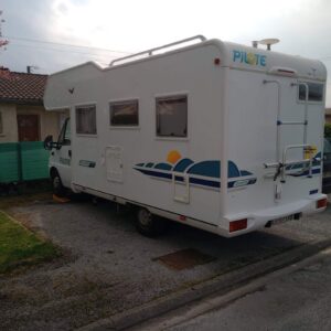 Camping-car Pilote garé devant une maison